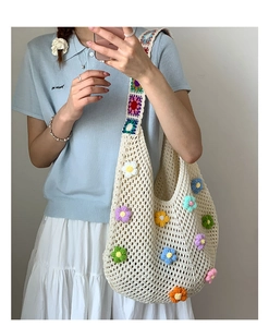 Close-up of 3D crochet flowers and intricate mesh weave on beige knit hobo tote bag
