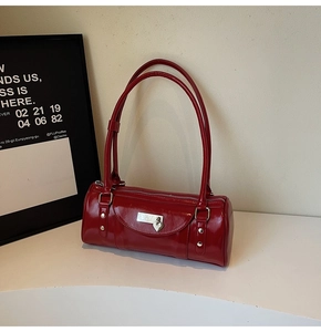 Detail of dark red bowling bag with silver heart lock and glossy leather finish