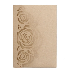 Macro detail of laser-cut rose patterns on dark beige kraft paper wedding invitation