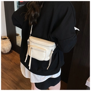 Mannequin portant un sac seau minimaliste en cuir beige dans un intérieur élégant