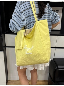 Yellow large capacity tote bag with small pouch and artistic typography for daily commute