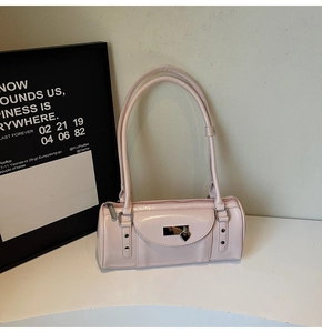 Close-up of pink bowling handbag with glossy finish, silver heart lock and double straps