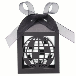 Detail of matte black laser-cut gift box featuring hollow globe pattern and ribbon bow