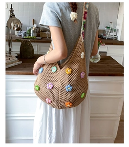 Detail of hollow knit tote bag featuring colorful 3D crochet flowers and boho straps
