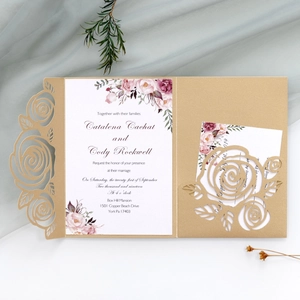 Detail of laser cut gold rose wedding invitation with elegant floral insert card