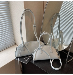 Detailed view of light blue shell bags with bow accents and adjustable shoulder straps