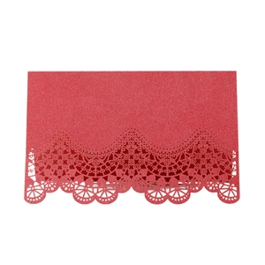 Detail of red laser-cut place card with vintage lace pattern and subtle glitter texture