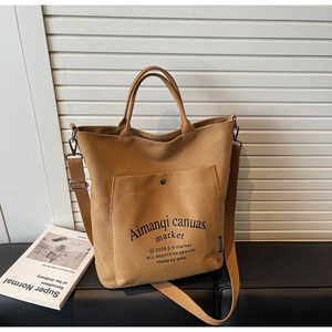 Brown canvas tote bag with front snap pocket, dual handles and adjustable shoulder strap
