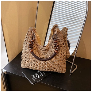 Detailed view of woven straw tote bag with rustic wooden beads and cotton lining