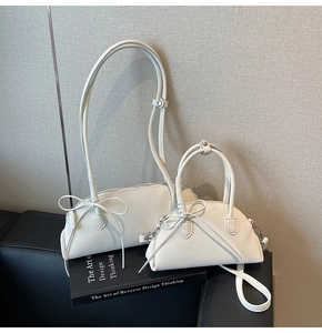 Detail of cream white shell bags with lychee texture PU leather and bow tie decoration