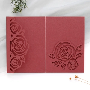 Close-up of laser-cut burgundy rose patterns on high-quality cardstock wedding invitation