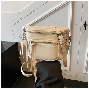 Détail du sac seau bandoulière en cuir PU blanc crème avec texture lisse et zips argentés