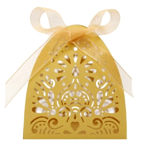 Detail of laser-cut gold wedding favor box with heart pattern and organza ribbon bow