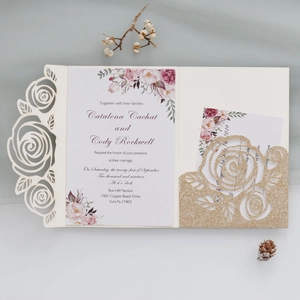 Detail of laser-cut rose wedding invitation set with floral insert and gold glitter pocket