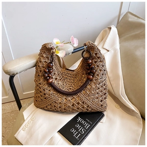 Close-up of woven straw tote bag featuring decorative dark brown wooden bead handles