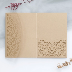 Detail of laser-cut gold pearlescent invitation holder with elegant vine patterns