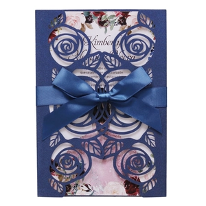 Detail of laser-cut rose patterns on pearlescent navy card with a satin ribbon bow