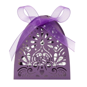 Detail of purple laser-cut wedding favor box with intricate floral patterns and organza ribbon