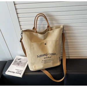 Macro shot of durable beige canvas tote bag with front pocket and adjustable strap