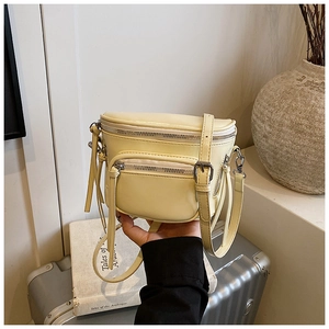 Détail du sac bandoulière en cuir PU crème montrant la texture lisse et les zips argentés