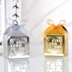 Detail view of gold and silver globe-shaped hollow candy boxes with organza ribbons