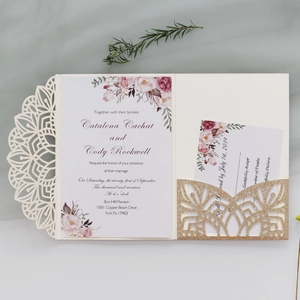 Detail of laser-cut mandala wedding invitation with floral insert and gold glitter pocket