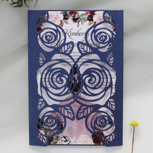 Detailed laser-cut navy blue wedding invitation with intricate rose hollow patterns