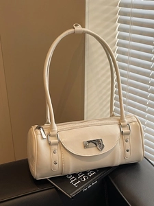 Creamy barrel-shaped bowling bag with heart lock and silver hardware on a black surface
