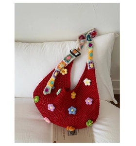 Close-up of red crochet tote bag with colorful 3D knitted floral pattern detail