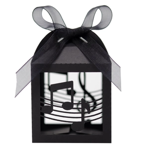 Detail of black laser-cut musical note candy box with elegant organza ribbon bow
