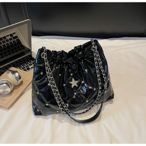 Détail du sac seau noir matelassé avec clous étoiles argentés et bandoulière chaîne