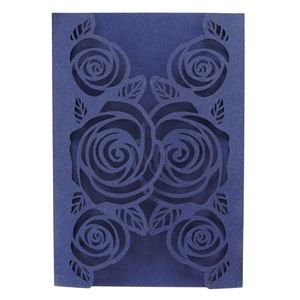 Macro detail of laser-cut rose patterns on pearlescent navy blue wedding invitation card