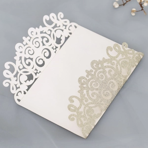 Detail of laser-cut wedding invitation pocket with champagne glitter floral patterns