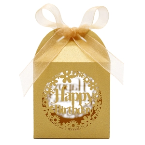 Macro shot of laser-cut Happy Birthday floral pattern on champagne pearl paper gift box
