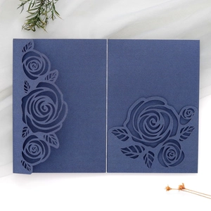 Close-up of laser-cut rose details on dark green wedding invitation card