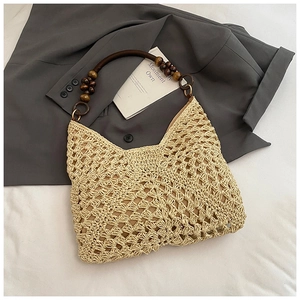 Detail of beige woven tote bag with dark brown wood bead handles and metal ring accents