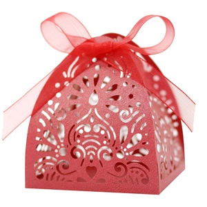 Elegant red laser-cut favor box with heart patterns and a matching ribbon bow
