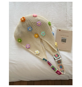 Detail of bohemian knit tote bag showing colorful 3D crochet flowers and wide strap