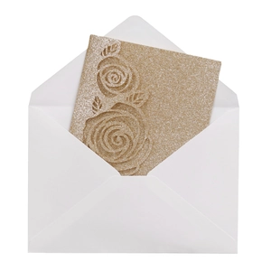 Detail of laser cut gold glitter wedding invitation with embossed rose pattern and envelope