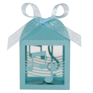 Detail of light blue laser-cut candy box featuring musical note patterns and silk ribbon
