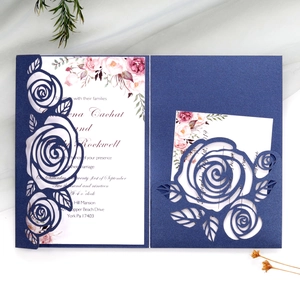 Macro detail of laser-cut rose hollow pattern on dark green pearlescent wedding card