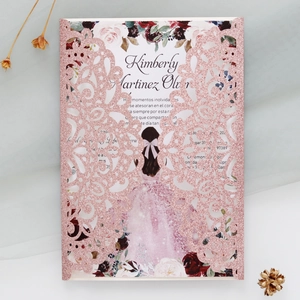 Detailed laser-cut glitter wedding invitation with floral insert on soft blue fabric