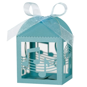 Detail of light blue laser-cut music theme candy box with notes and white ribbon
