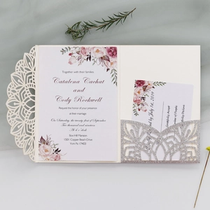 Detail of laser-cut floral wedding invitation set with silver glitter pocket and cream shell