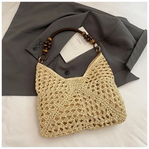 Close-up of beige crochet straw tote with dark brown wooden bead handles for summer
