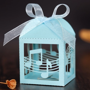 Close-up of light blue laser-cut music themed gift box with musical notes and ribbon