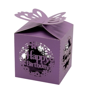 Macro detail of laser-cut Happy Birthday paper gift box with butterfly top and daisy patterns