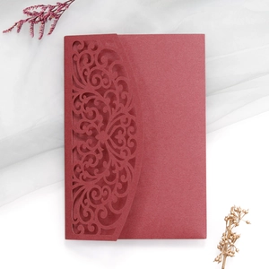 Close-up of burgundy laser-cut floral wedding invitation with pearlescent finish