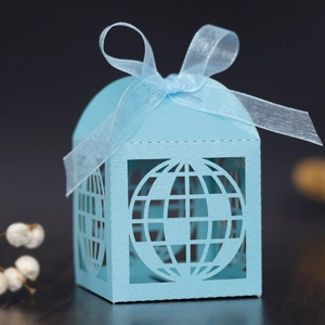 Close-up of light blue laser-cut globe gift box with ribbon for wedding party favors