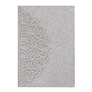 Close-up of silver glitter wedding invitation with laser-cut mandala floral patterns